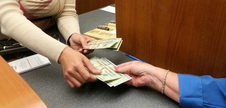 woman cashing her stimulus check at the bank