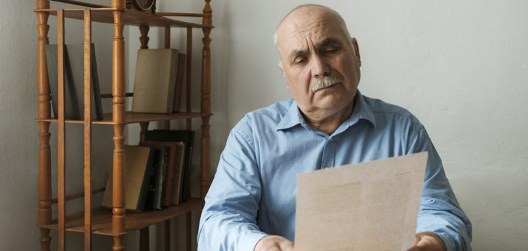 an older businessman reading an IRS audit letter