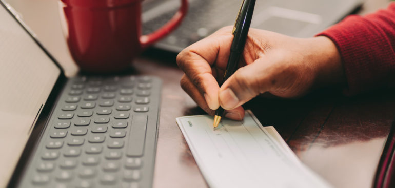 man writing a check to the IRS for his Offer in Compromise payment