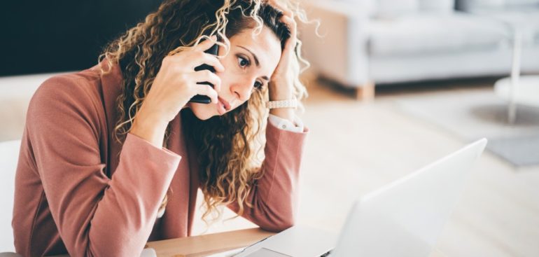 a worried woman on the phone with an IRS scammer